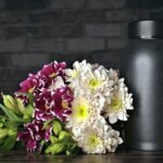 Urna funerária com flores, simbolizando a diferença entre sepultamento e cremação.