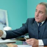 Agente segura mão de mulher enlutada, demonstrando o que faz um agente funerário com zelo.